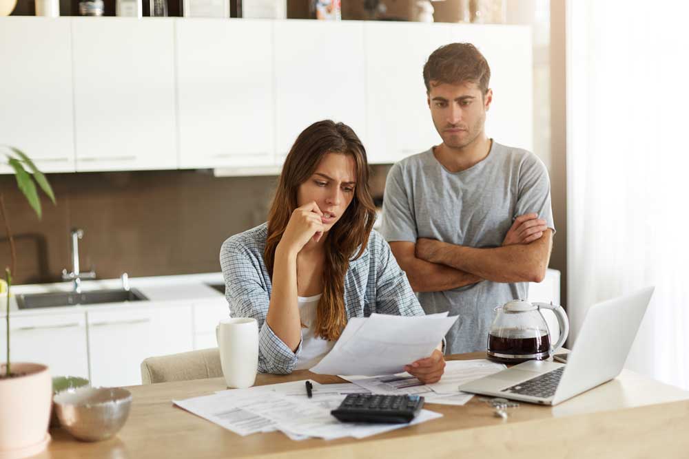 Pareja preocupada, haciendo cuentas por insolvencia financiera. Jinete y Asociados